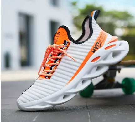 White knit running shoe with orange accents and an open-cutout white sole