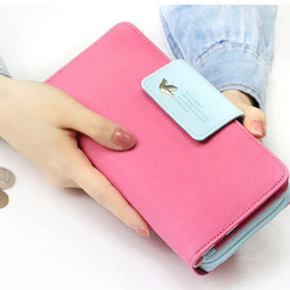 Pink coin purse wallet with light blue flap and gold-tone horse emblem designer wallet image
