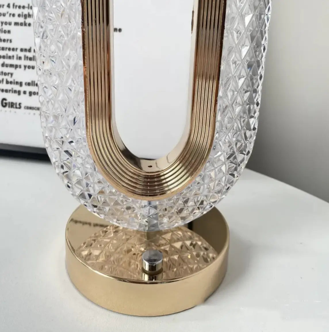 A sleek u-shaped crystal touch desk lamp with gold metallic frame and base for light luxury home decor