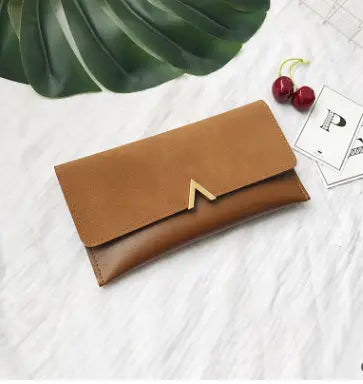 Tan leather multi-slot long wallet with a gold-tone triangular clasp shown in a long wallet image