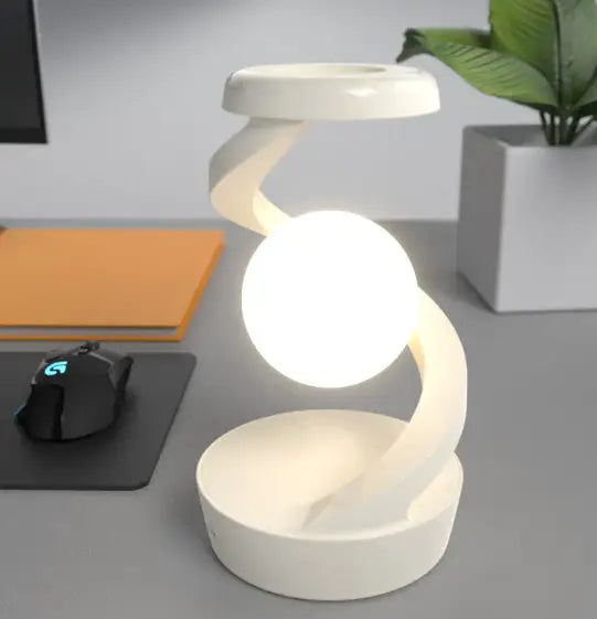 White rotating moon desk lamp with sleek curved design and glowing spherical light fixture with wireless charger